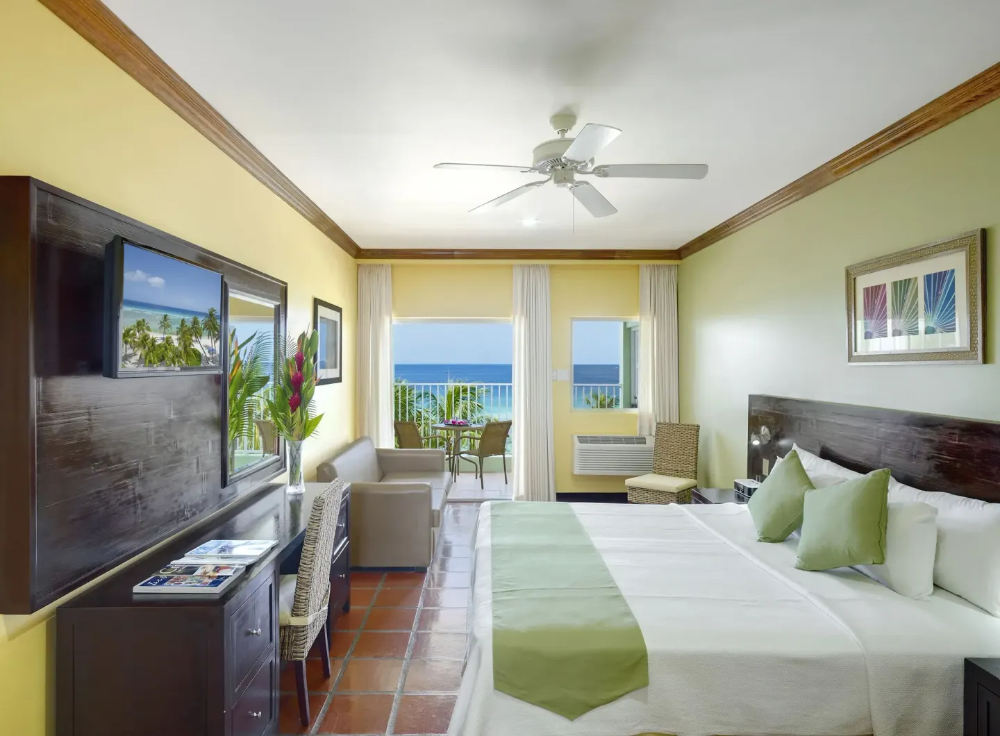Superior Oceanfront room with bed, seating, TV, and balcony at Coconut Court Beach Hotel.