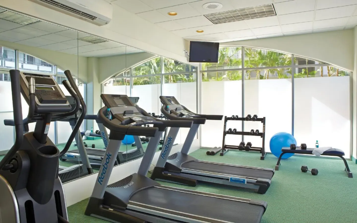 Fitness room with treadmills and free weights at Coconut Waikiki Hotel.