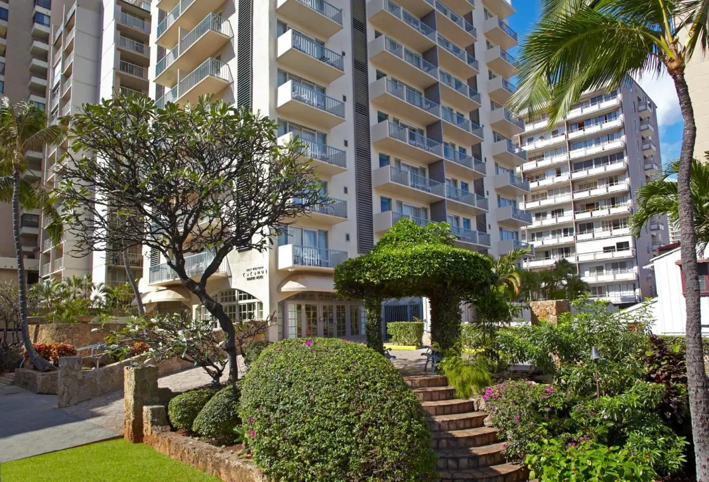 Hotel exterior with balconies and tropical landscaping at Coconut Waikiki Hotel.