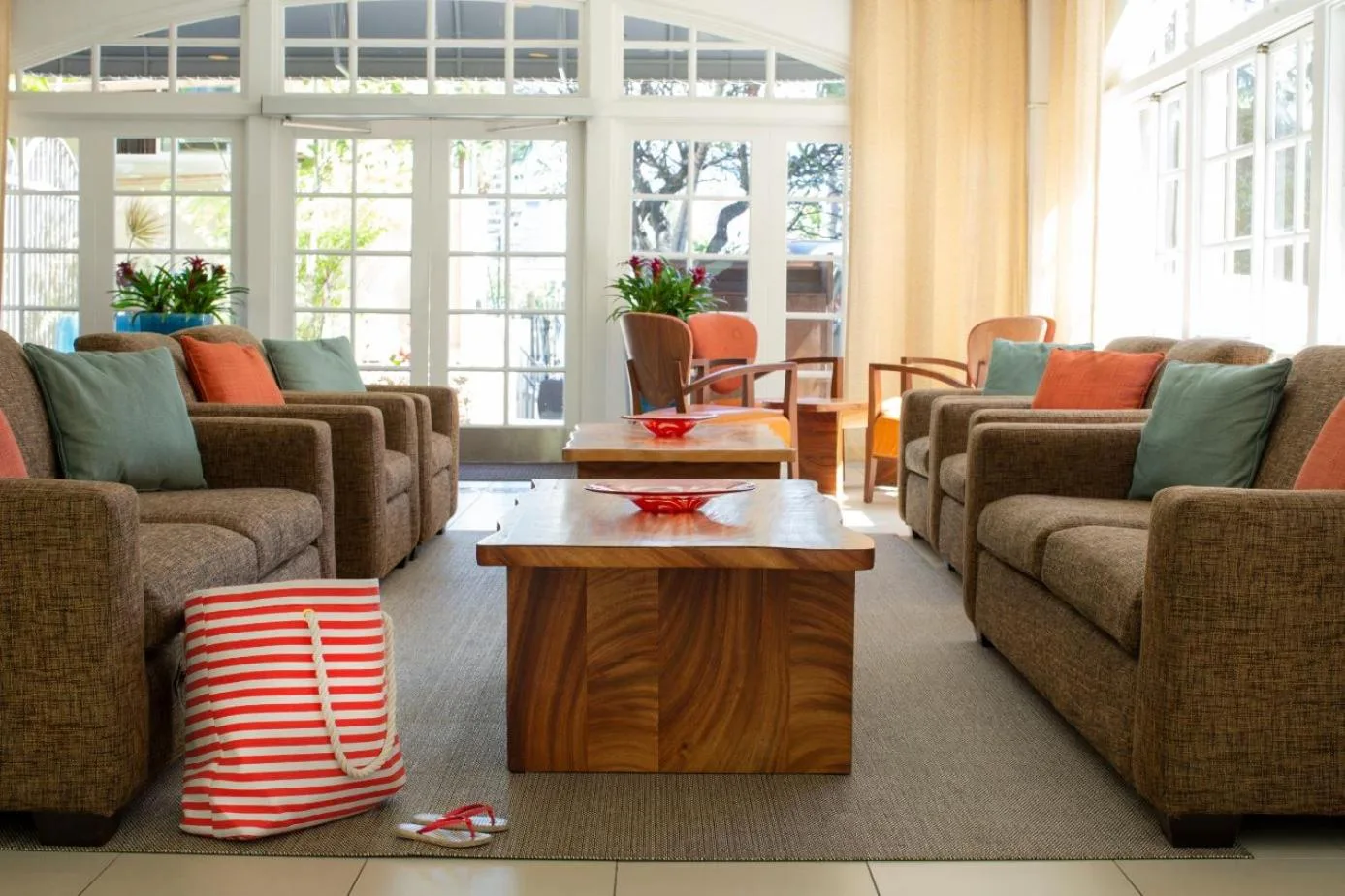 Lobby lounge with sofas, pillows, and wood tables at Coconut Waikiki Hotel.