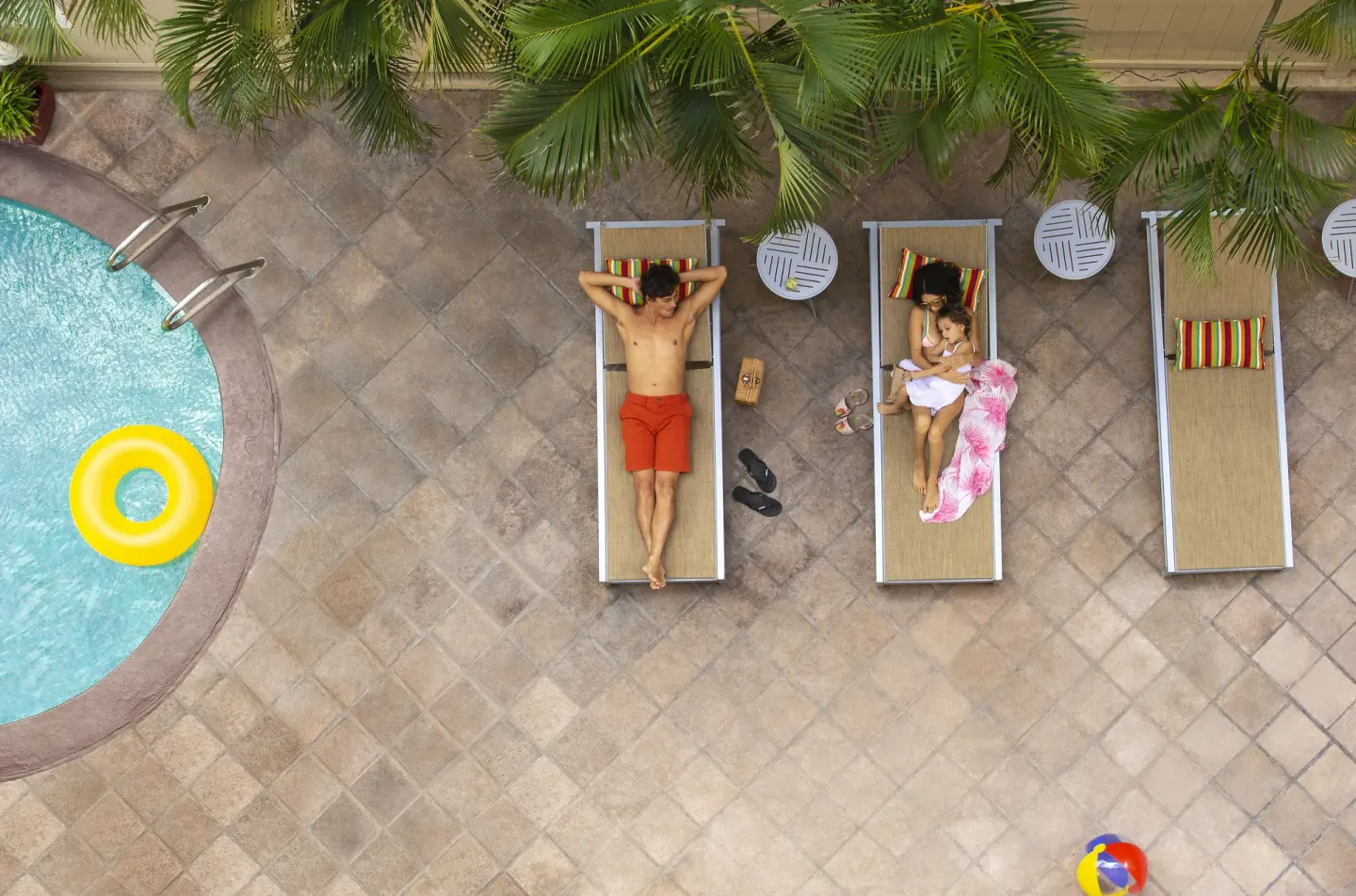 Overhead view of pool loungers and a yellow float at Coconut Waikiki Hotel.