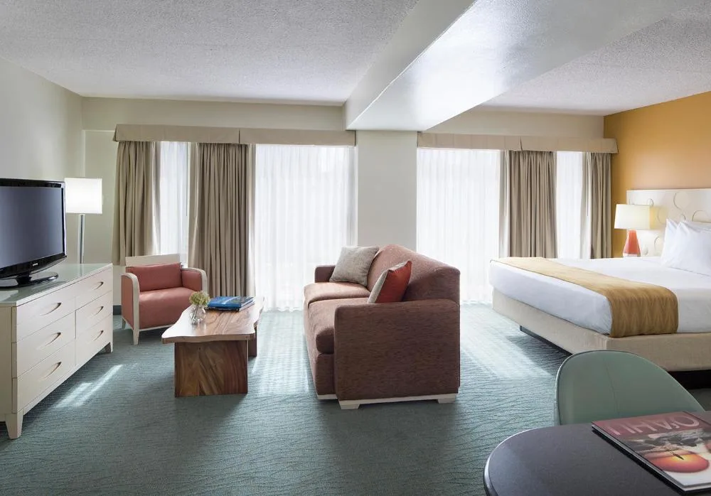 Executive Suite guest room with king bed and sitting area at Coconut Waikiki Hotel.