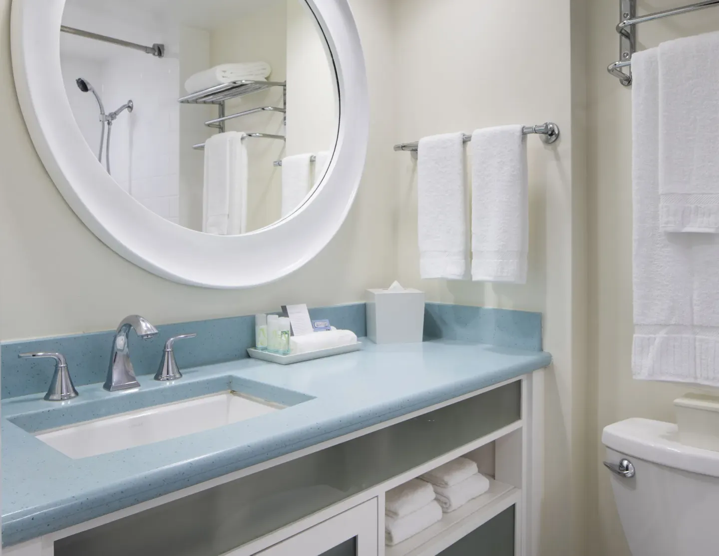 Standard Room City View bathroom vanity with towels and round mirror at Coconut Waikiki Hotel.