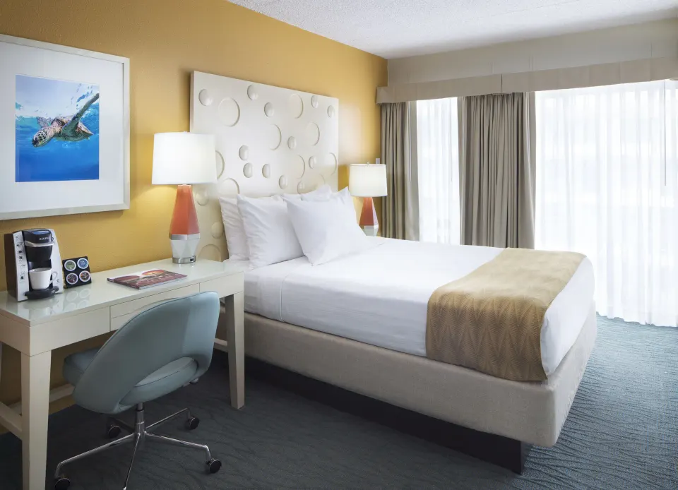 Standard Room City View king bed with desk and bright window at Coconut Waikiki Hotel.