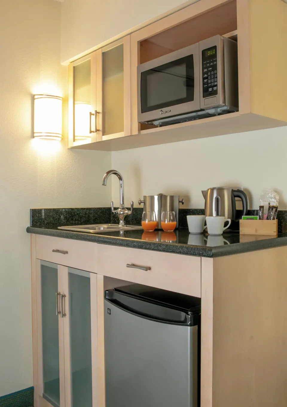 Standard Room City View kitchenette counter with sink and microwave at Coconut Waikiki Hotel.