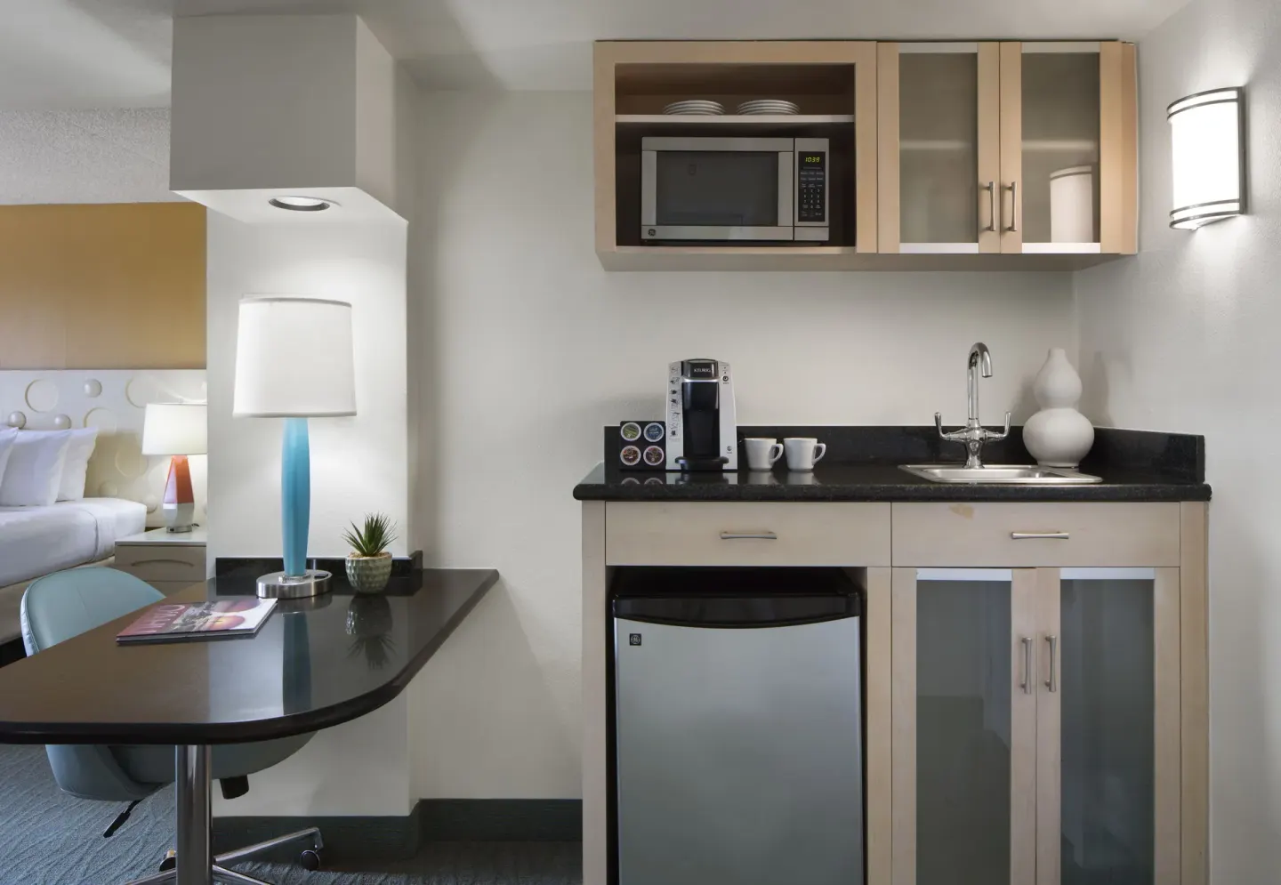 Standard Room City View kitchenette with sink, microwave, and mini fridge at Coconut Waikiki Hotel.