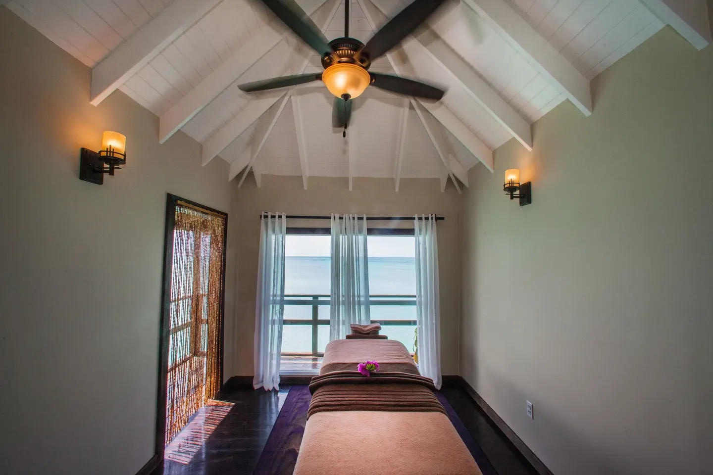 A single spa treatment bed sits beneath a vaulted ceiling at COCOS Hotel.