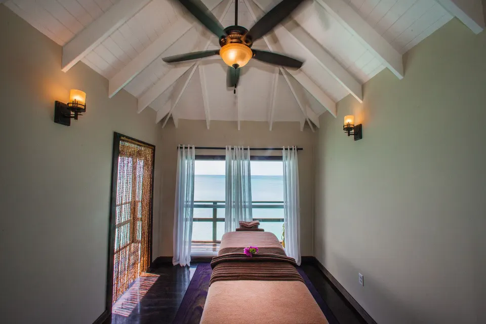 A single spa treatment bed sits beneath a vaulted ceiling at COCOS Hotel.