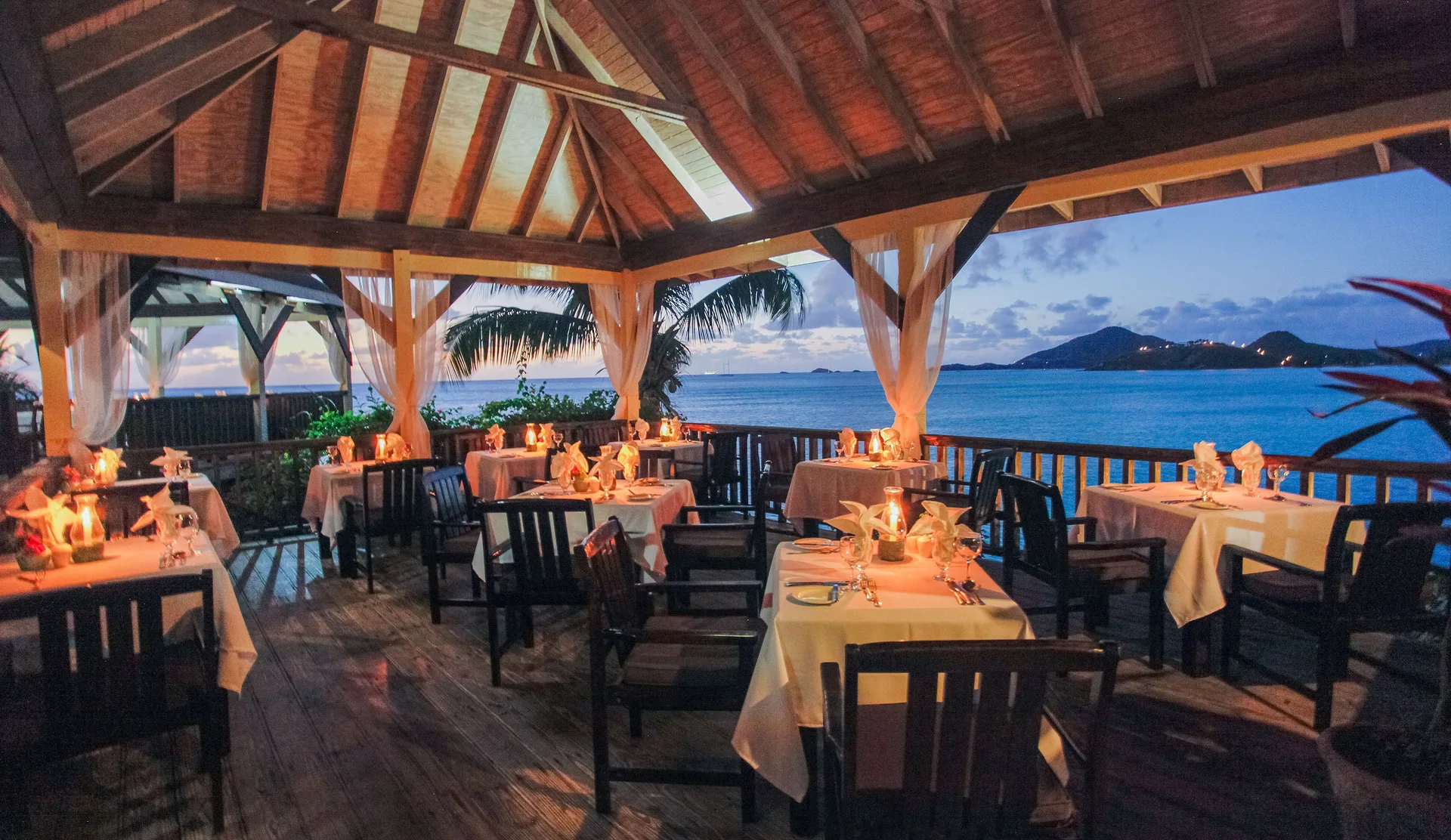Candlelit tables overlook the sea in the open-air restaurant at COCOS Hotel.