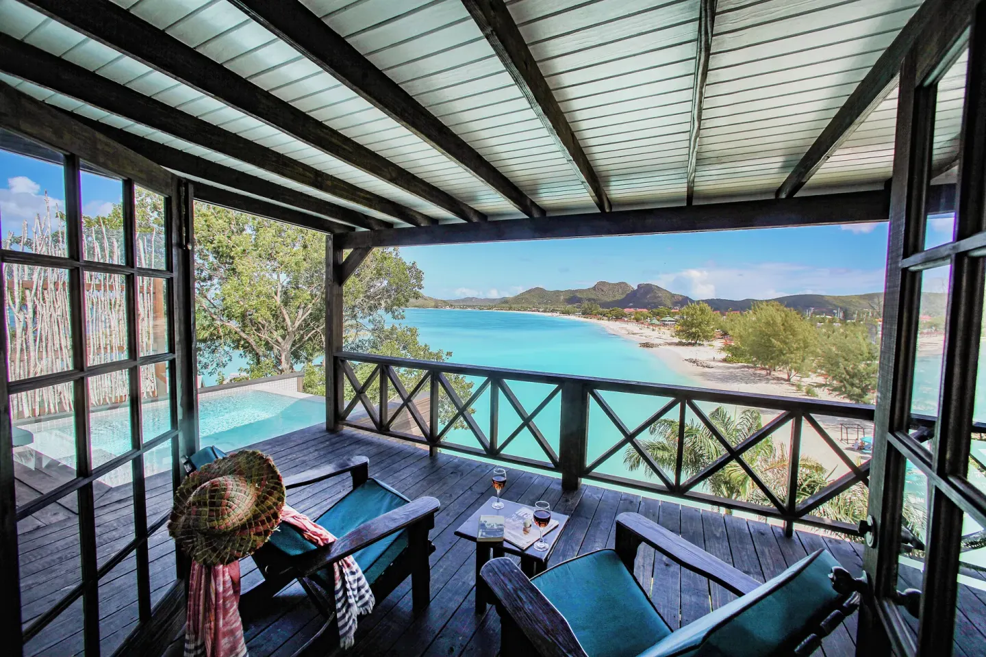 Bay View Pool Cottage covered veranda with chairs and bay views at COCOS Hotel.