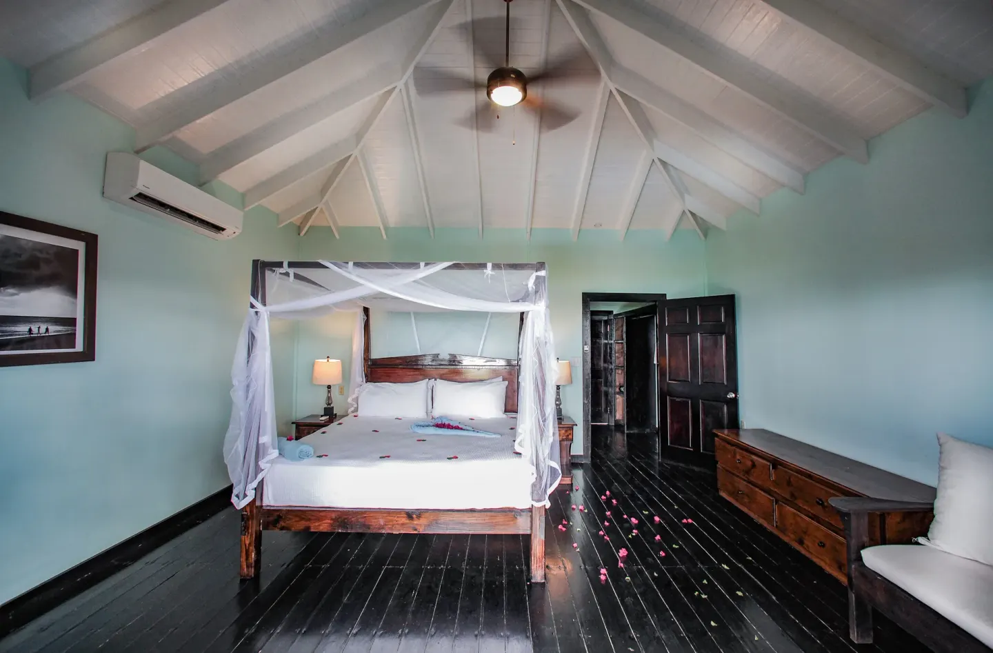 Beach Front Pool Cottage bedroom with canopy bed and seating at COCOS Hotel.