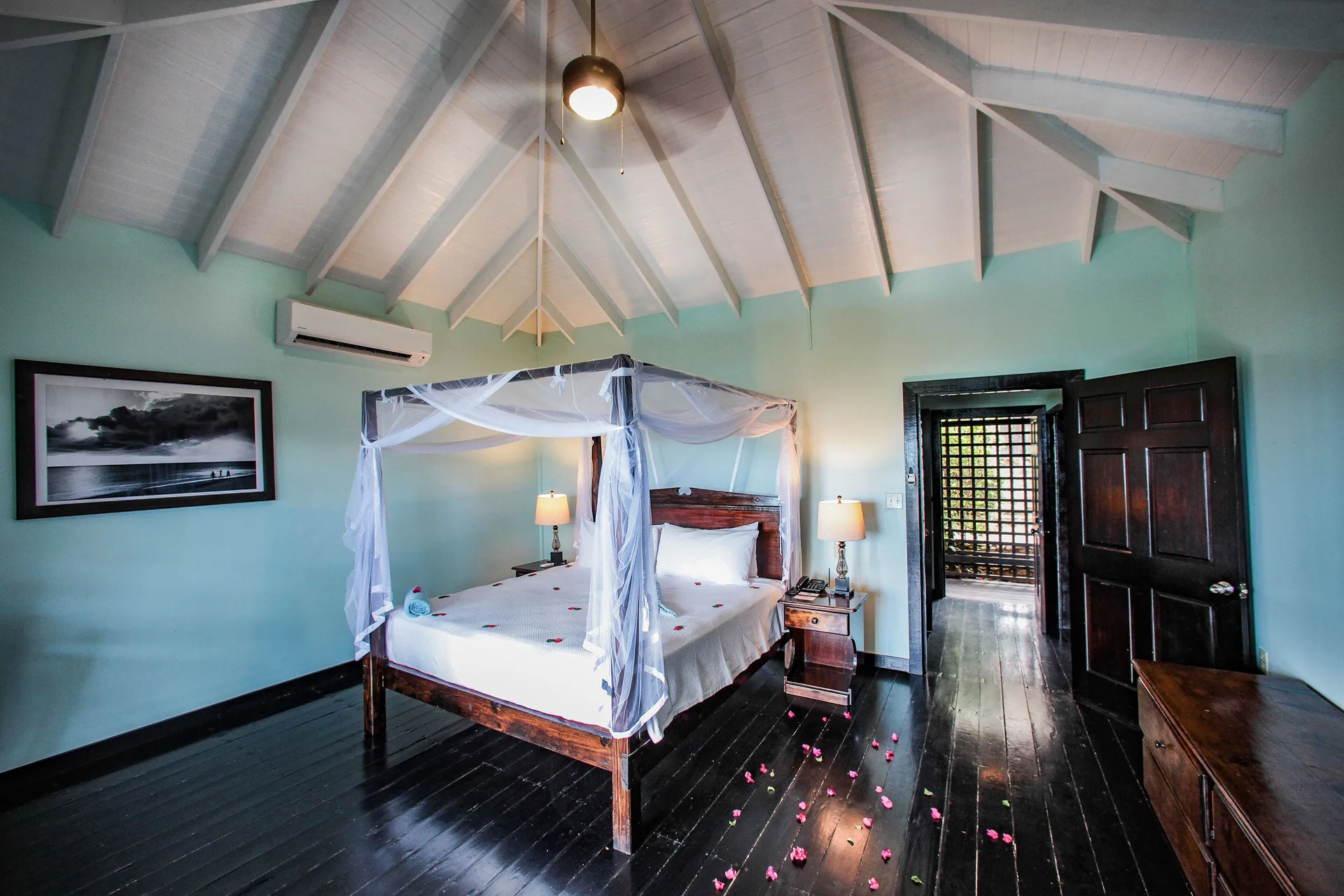 Beach Front Pool Cottage bedroom with four-poster bed at COCOS Hotel.