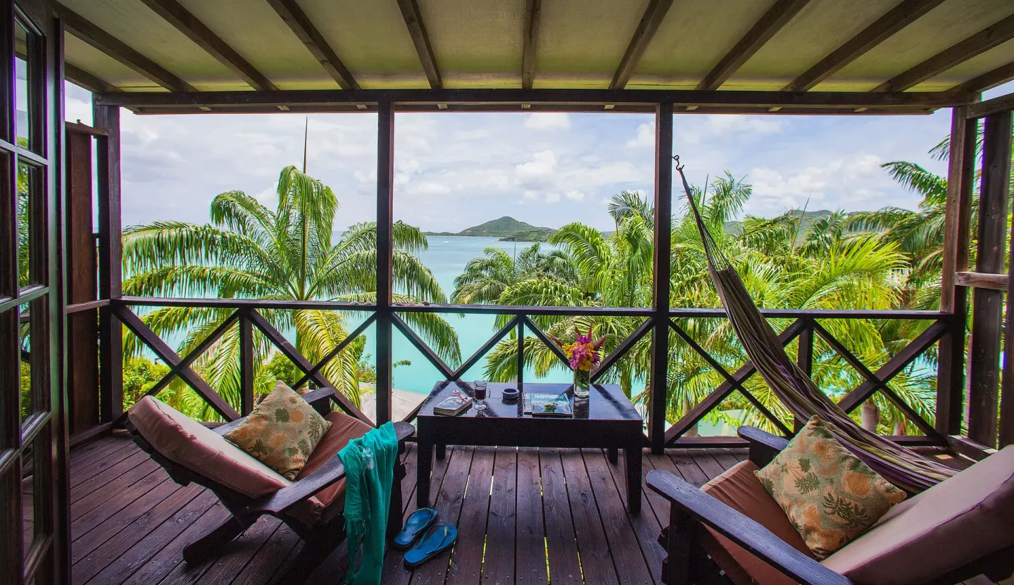 Premium View Cottage deck with loungers, hammock and sea view at COCOS Hotel.