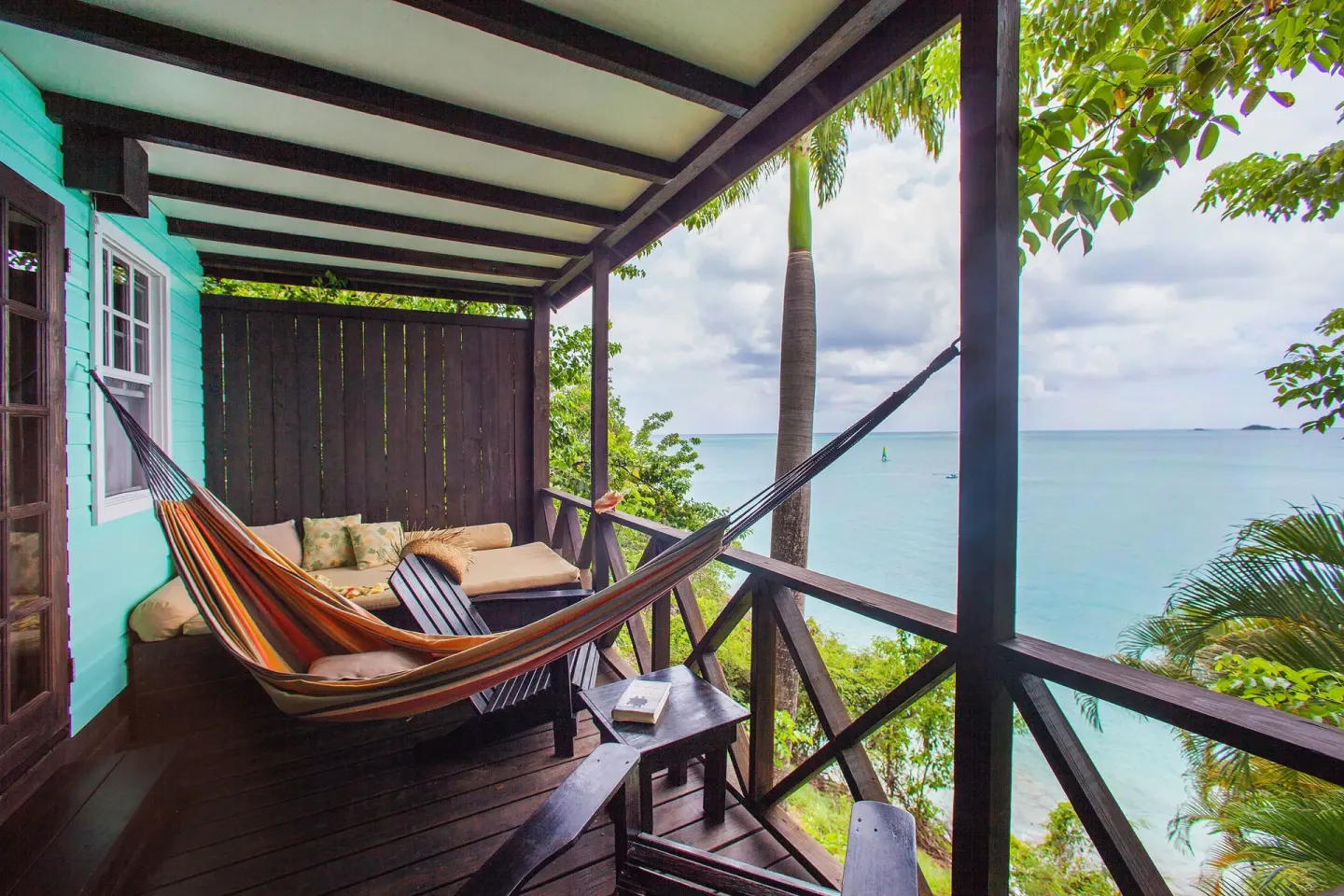 Premium View Cottage veranda with hammock and ocean view at COCOS Hotel.