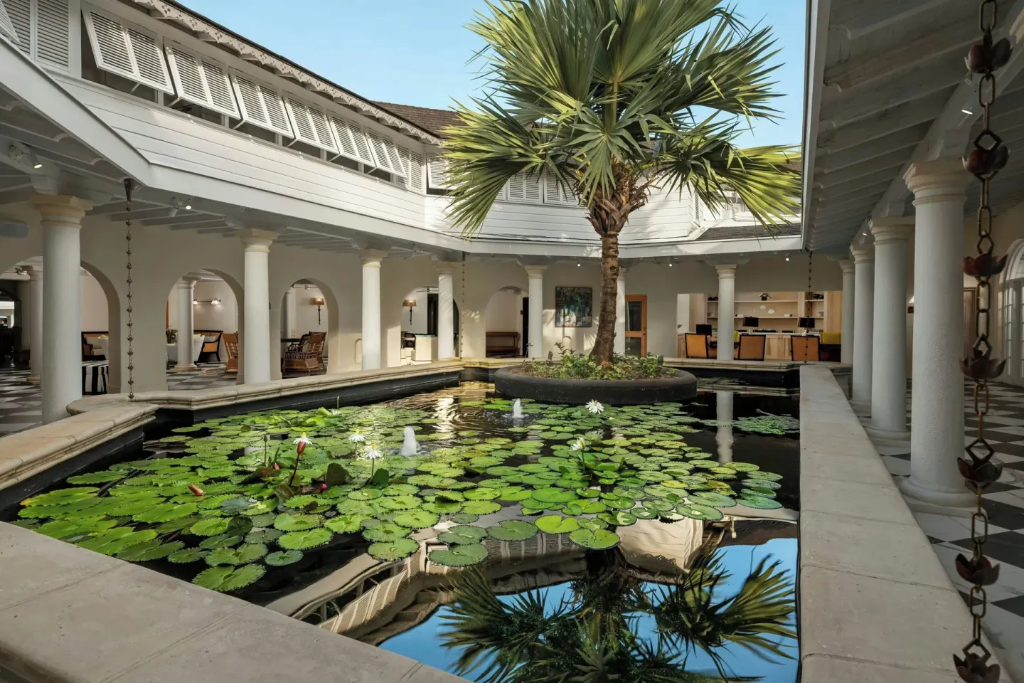 Lily pond courtyard with columns and a palm tree at Colony Club, Barbados.