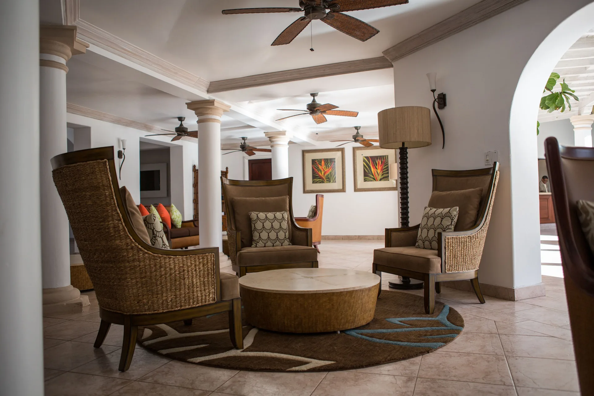 Lobby seating area with wicker chairs and ceiling fans at Colony Club, Barbados.