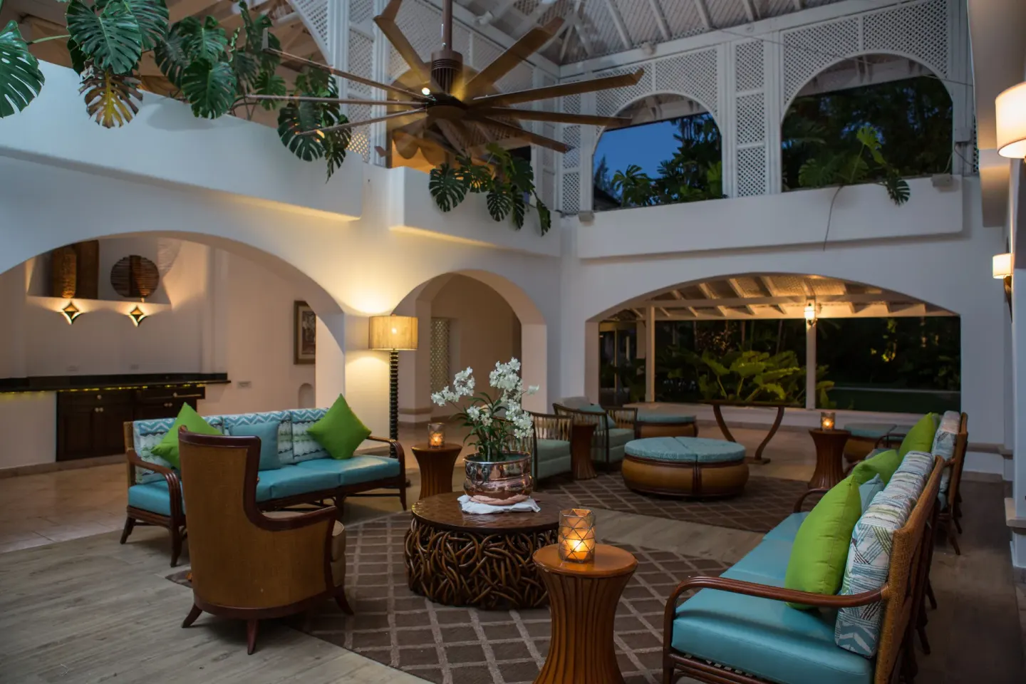 Open lounge with blue seating and arched white walls at Colony Club, Barbados.