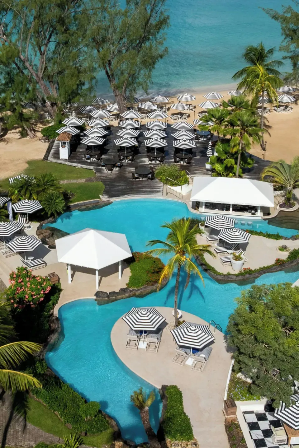 Aerial view of the pool, beach loungers and turquoise sea at Colony Club, Barbados.
