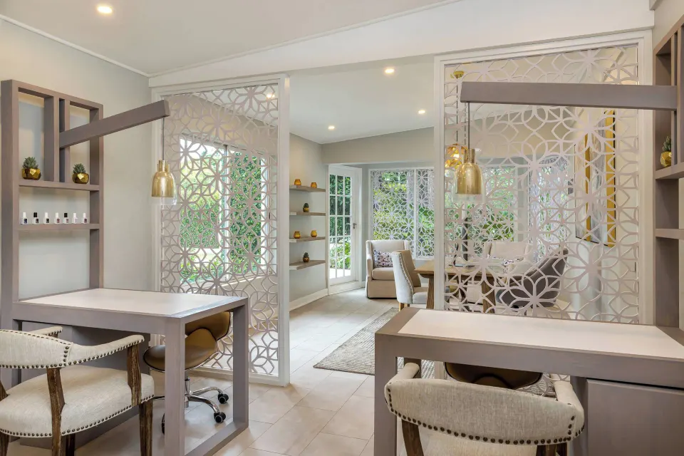 Bright salon with manicure stations and patterned screens at Colony Club, Barbados.