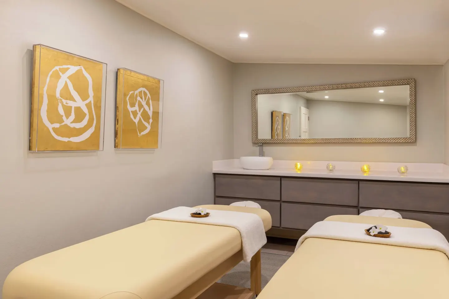 Spa treatment room with two massage tables and a long vanity at Colony Club, Barbados.
