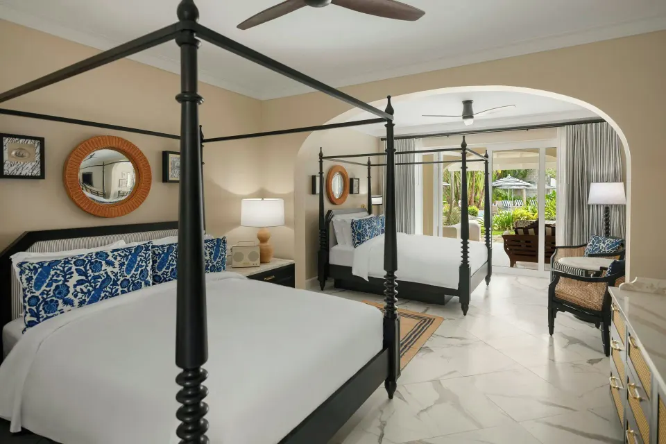 Junior Suite bedroom with two four-poster beds and terrace view at Colony Club, Barbados.
