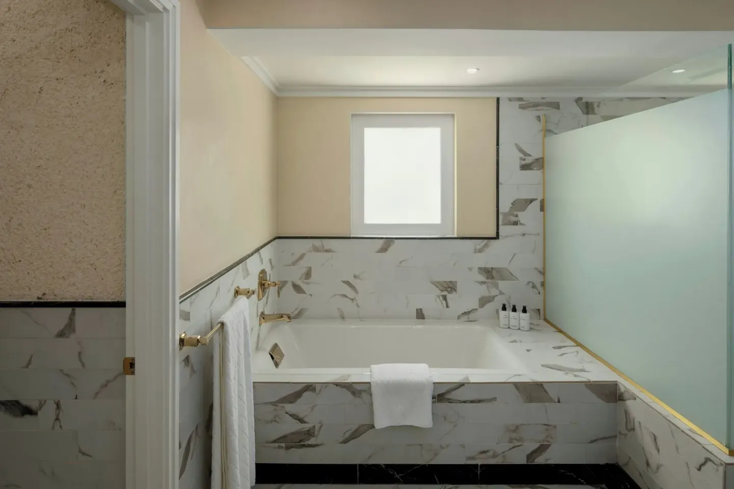 Suite bathroom soaking tub with marble-look surround at Colony Club, Barbados.