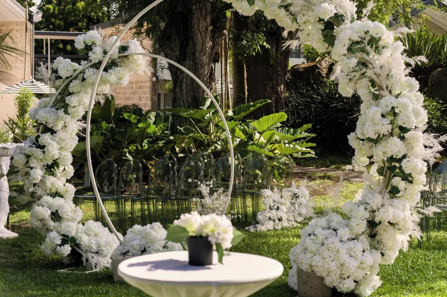 Garden wedding setup with white floral arches at Colony Club, Barbados.