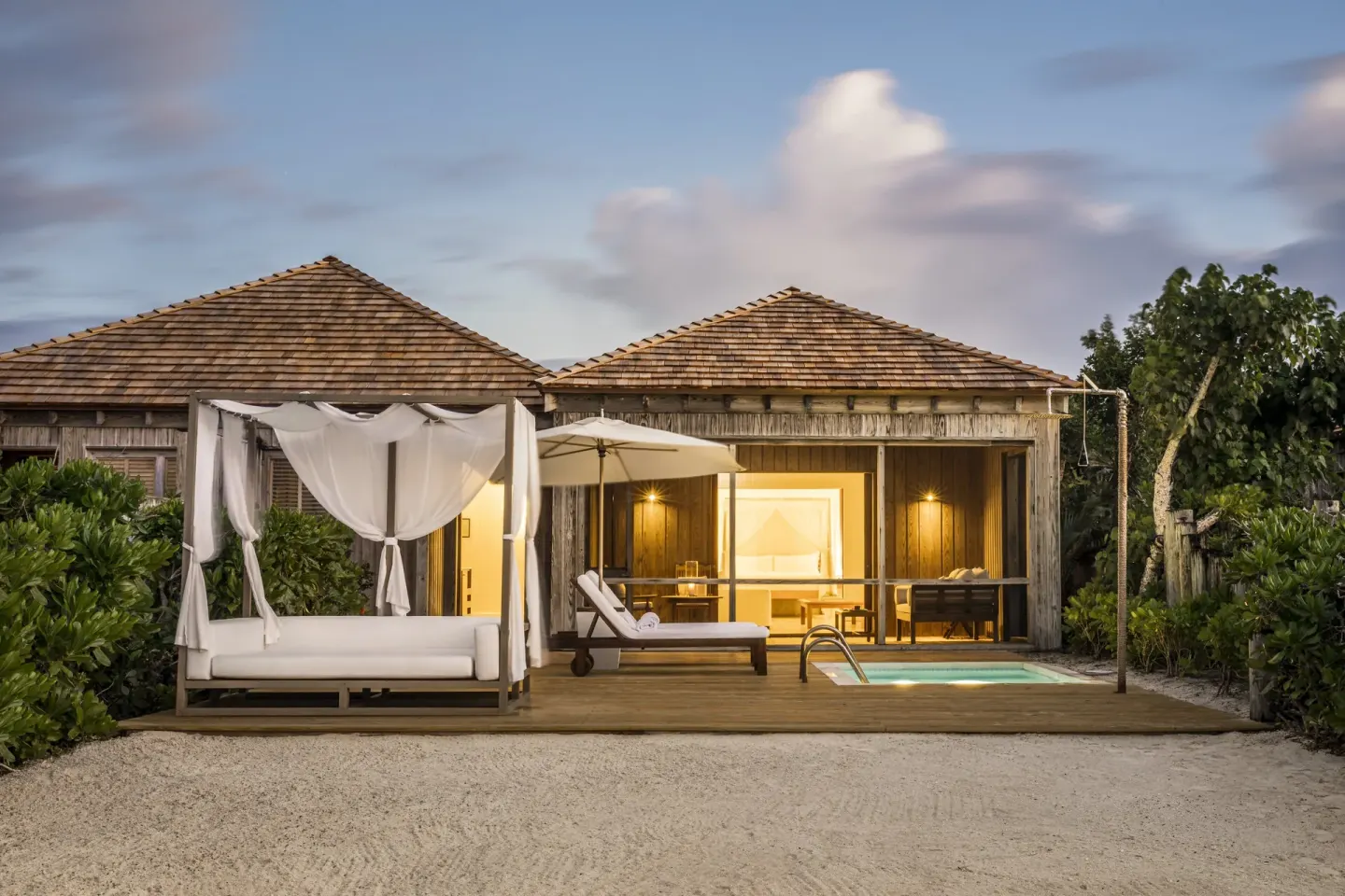 Beach villa exterior with plunge pool and canopy daybed at COMO Parrot Cay.