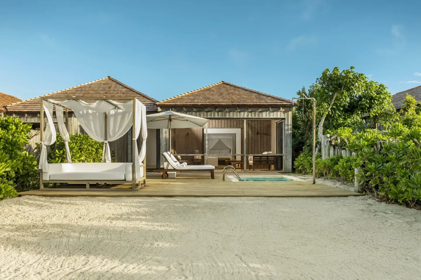 Beachfront villa deck with daybed, lounger and plunge pool at COMO Parrot Cay.