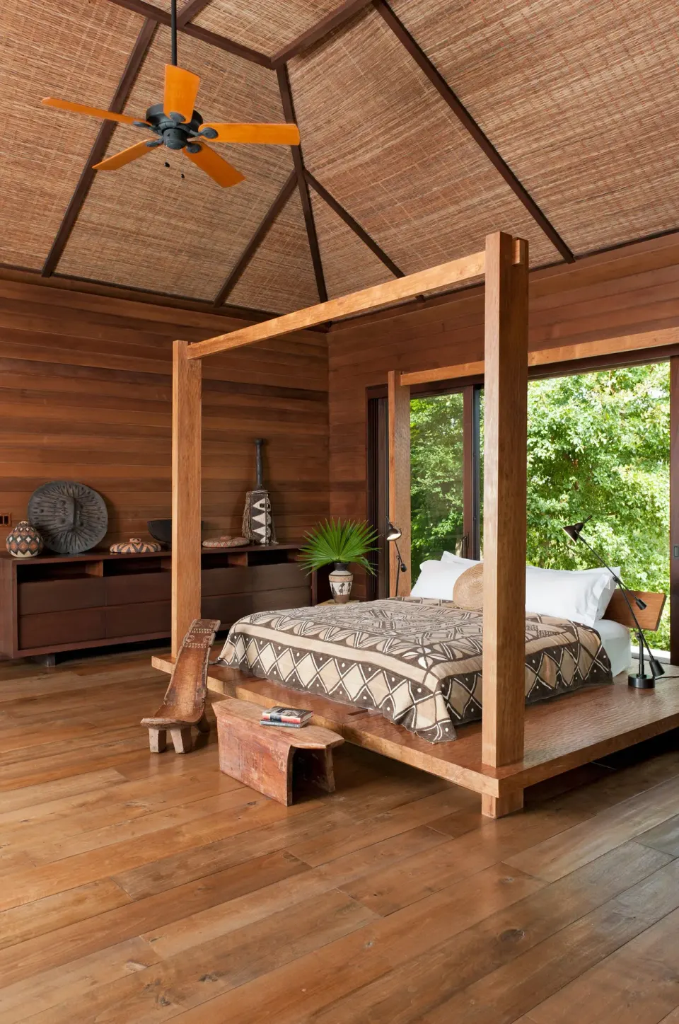 Wooden guest room with four-poster bed at COMO Parrot Cay.