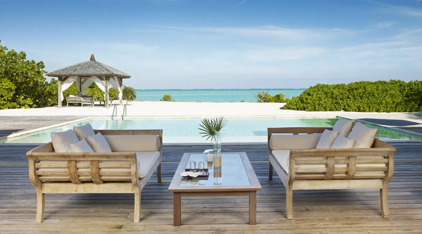 Pool deck with outdoor sofas, gazebo and ocean view at COMO Parrot Cay.