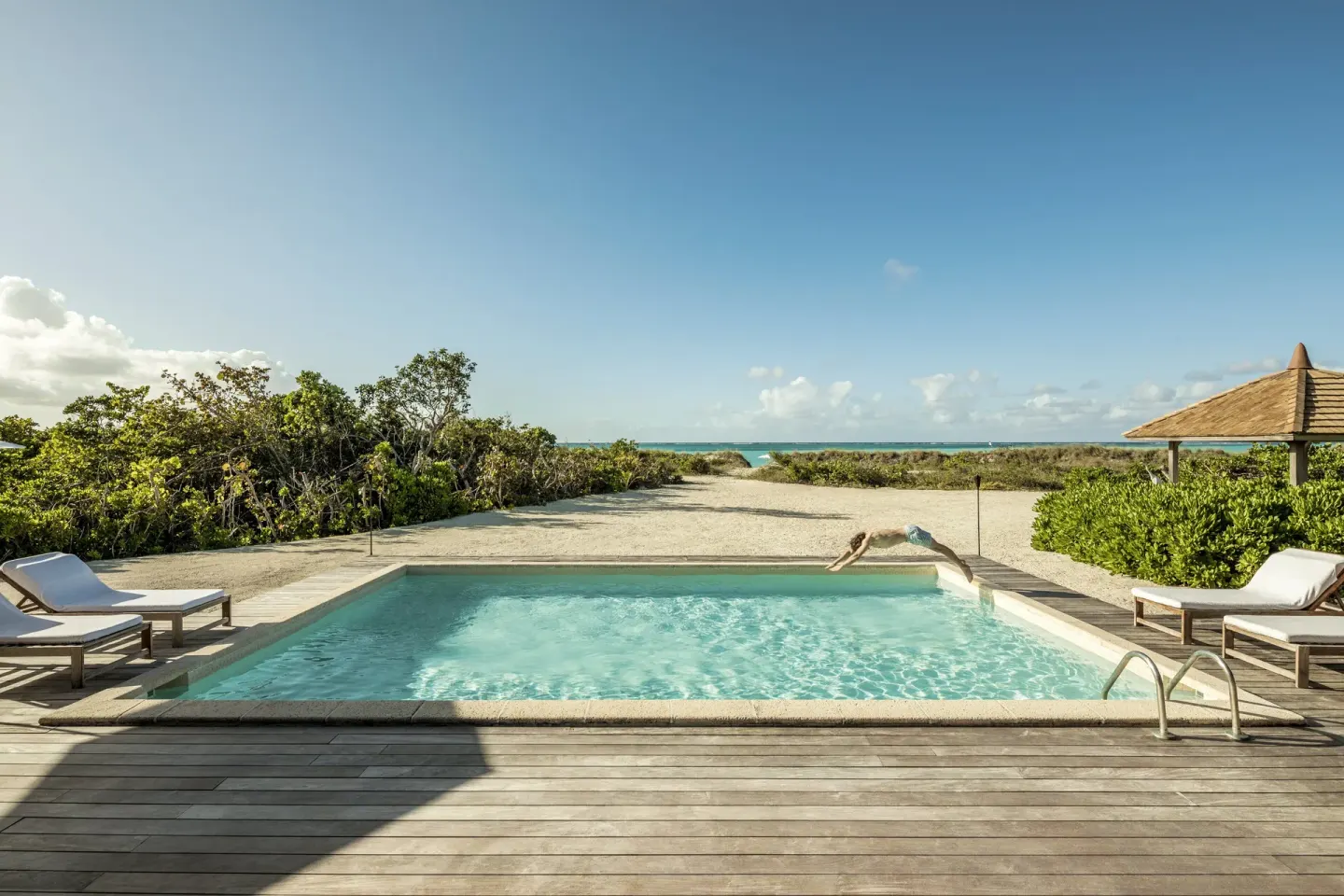 Private pool with loungers and ocean beyond at COMO Parrot Cay.