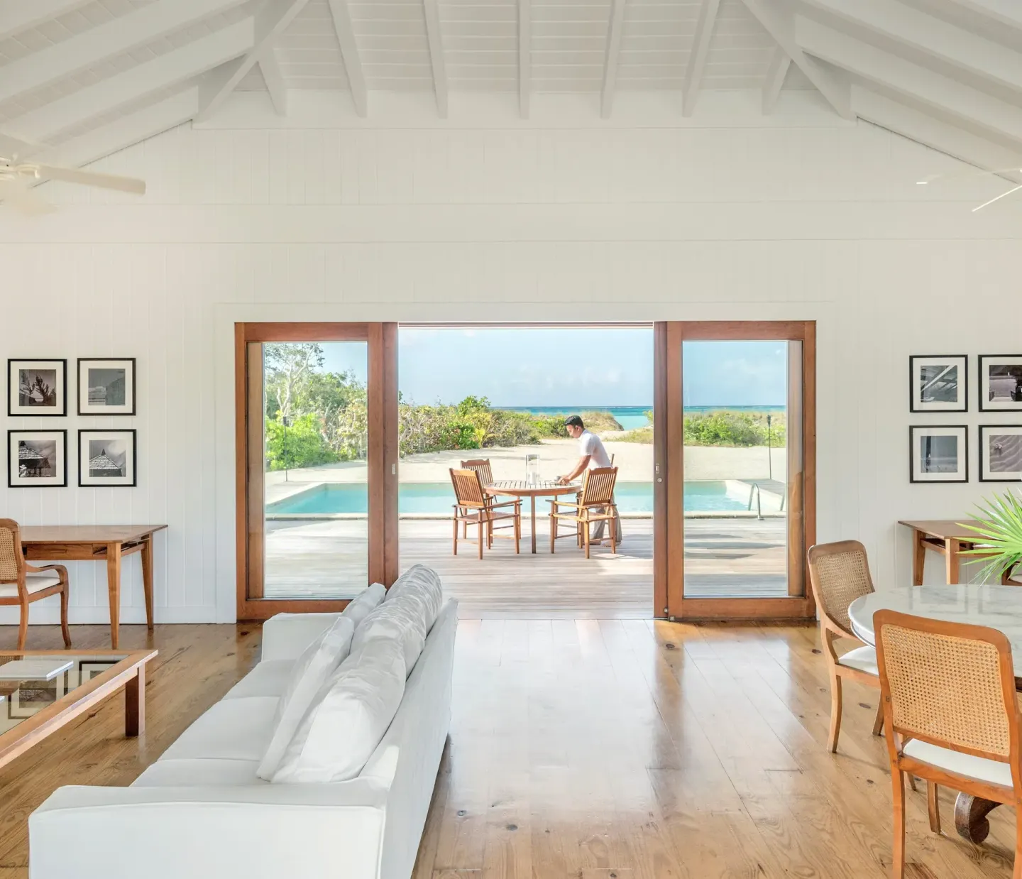 Bright villa living room at COMO Parrot Cay opening to a pool terrace and ocean view.