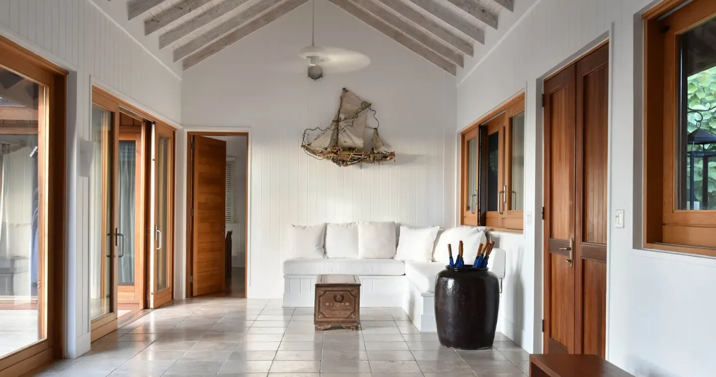 A high-ceilinged villa sitting area with white seating at COMO Parrot Cay.