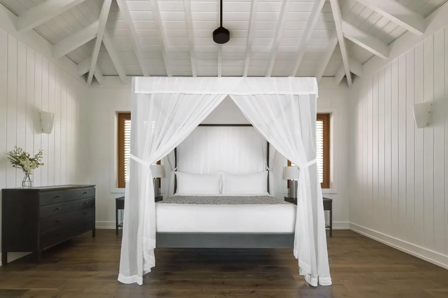 Beachfront Suite bedroom with a white canopy bed at COMO Parrot Cay.