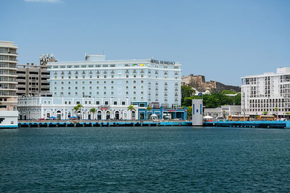 Hotel Rumbao, a Tribute Portfolio Hotel branded waterfront hotel with harbor views and modern exterior in Old San Juan, Puerto Rico.