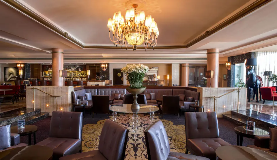 Lobby lounge seating beneath a chandelier at Condado Vanderbilt Hotel.