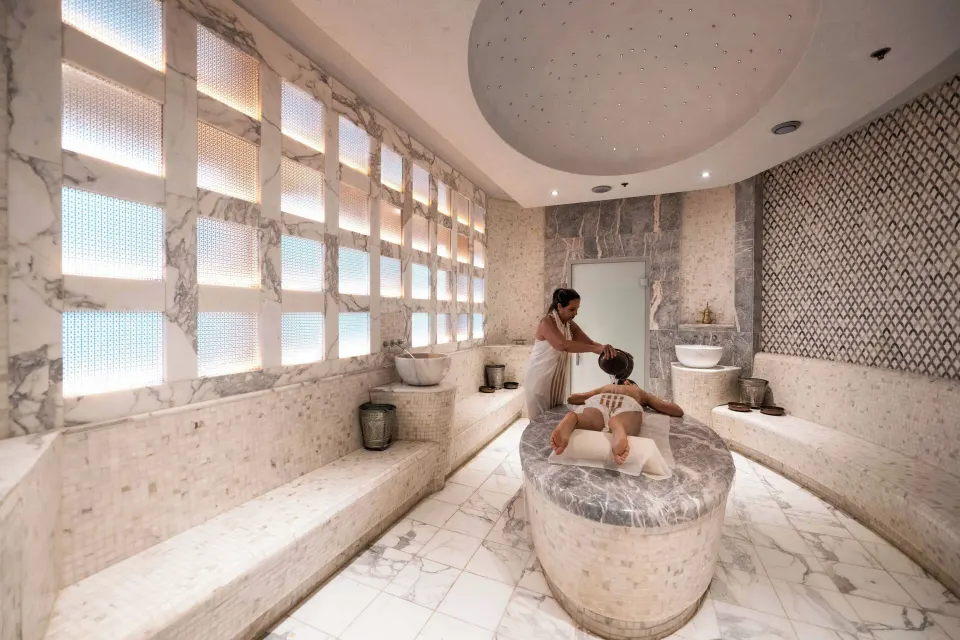 Marble spa treatment room with therapist and guest at Condado Vanderbilt Hotel.