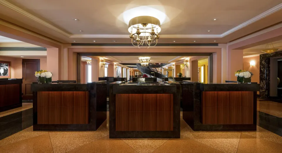 Reception desks and chandelier in the lobby at Condado Vanderbilt Hotel.