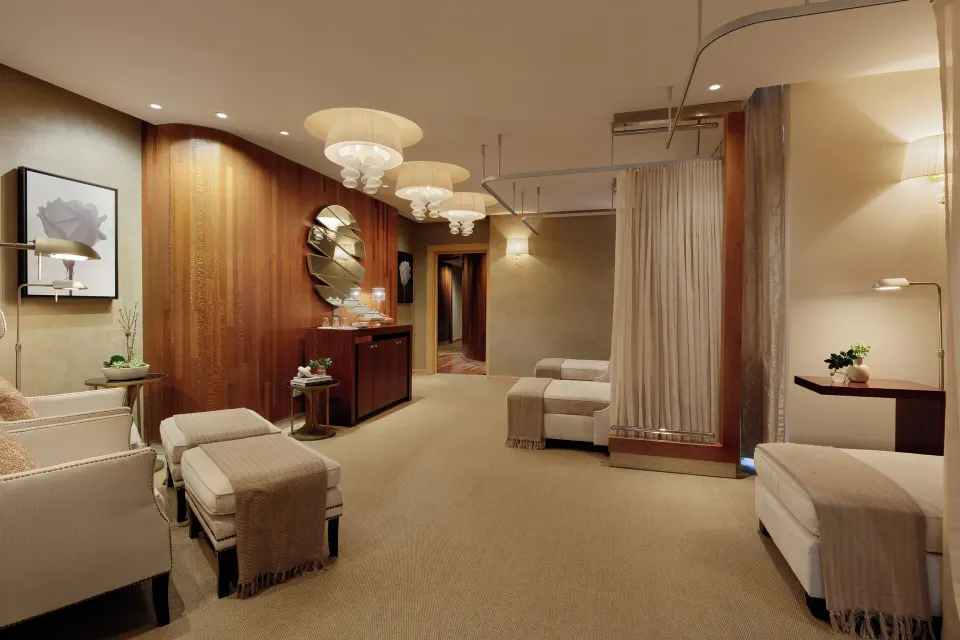 Spa relaxation lounge with chaise seating and wood-paneled walls at Condado Vanderbilt Hotel.