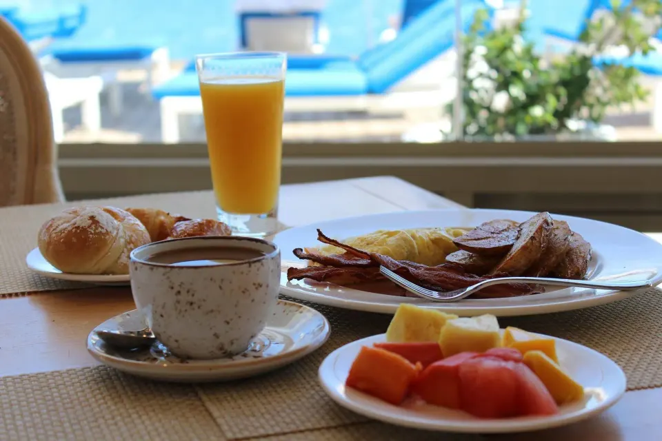 Breakfast table with coffee, juice, fruit, and bacon at Condado Vanderbilt Hotel.