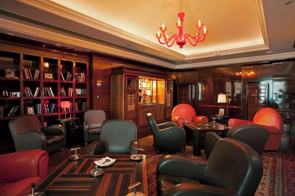 Cigar lounge seating with leather chairs and bookshelves at Condado Vanderbilt Hotel.