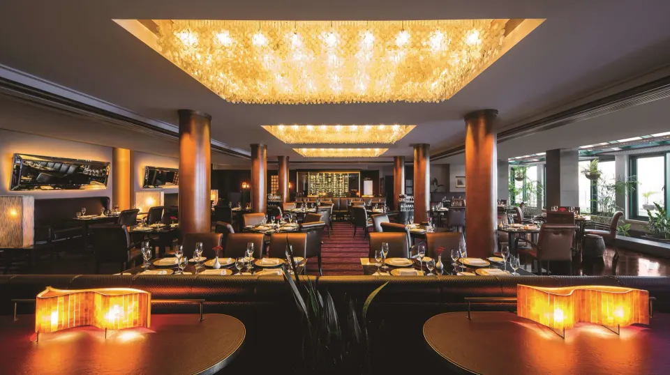 Elegant dining room with chandeliers and set tables at Condado Vanderbilt Hotel.