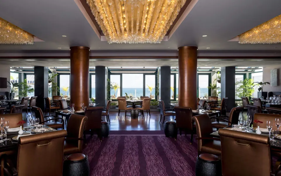 Elegant dining room with ocean-facing windows at Condado Vanderbilt Hotel.
