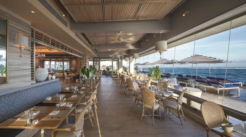 Oceanfront dining terrace with set tables at Condado Vanderbilt Hotel.