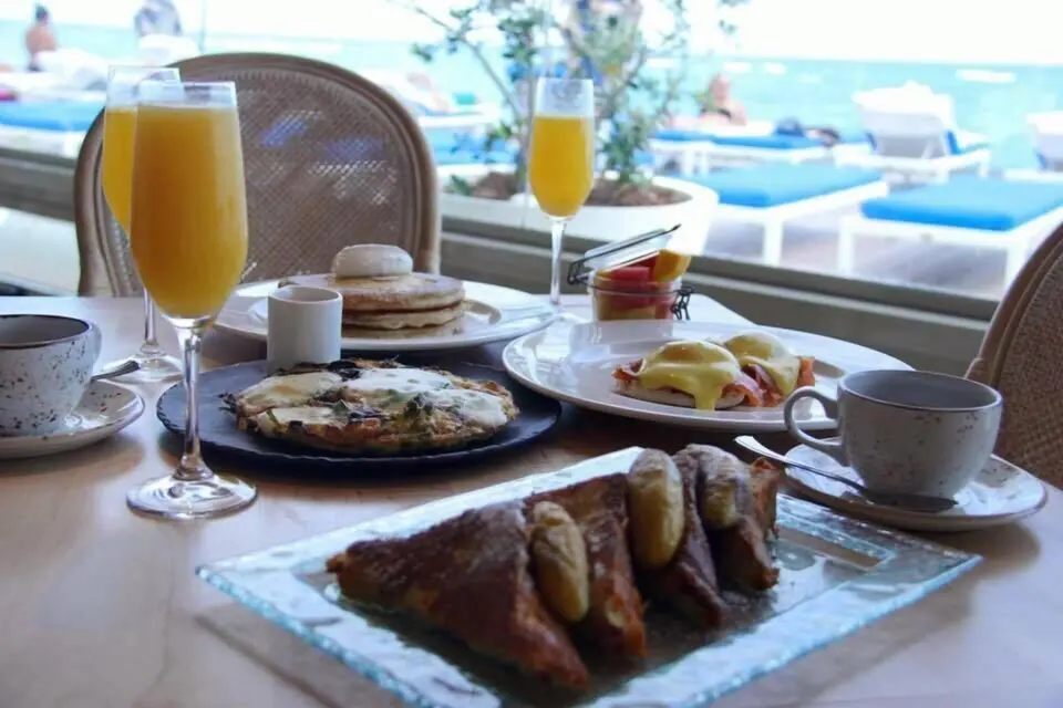 Breakfast plates and mimosas by the pool at Condado Vanderbilt Hotel.