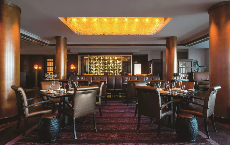 Restaurant dining room with wine display and set tables at Condado Vanderbilt Hotel.