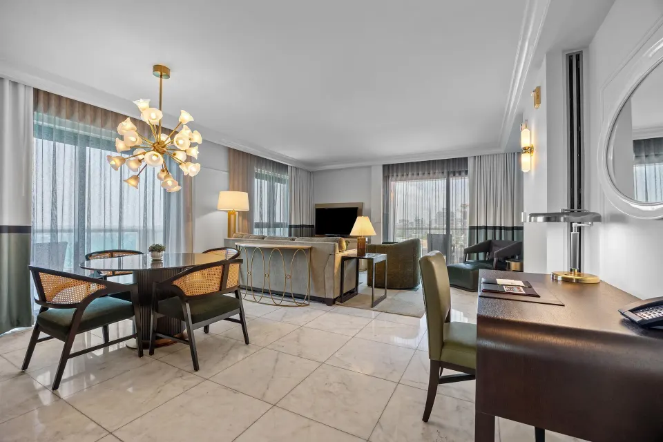 Living and dining area in the Commodore City View Two-Bedroom Room at Condado Vanderbilt Hotel.