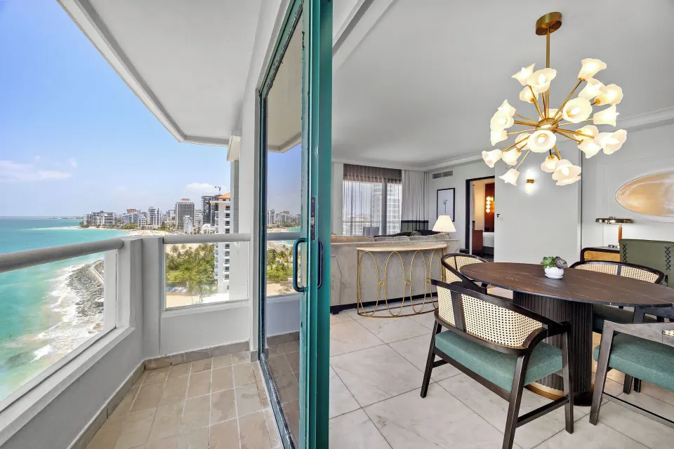 Balcony and dining area in a Commodore Oceanfront Room at Condado Vanderbilt Hotel.