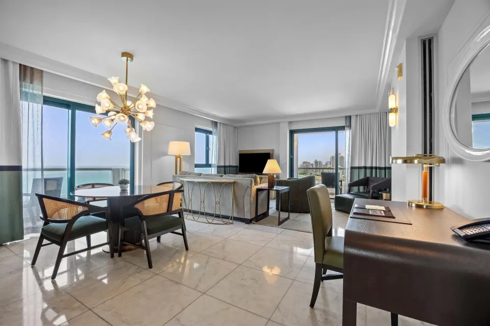 Living and dining area with ocean-facing windows at Condado Vanderbilt Hotel.